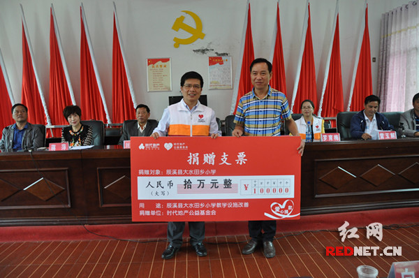 时代地产长沙公司总经理舒苏[左]向湖南省慈善总会代表蒋铁阳[右]捐赠爱心支票。